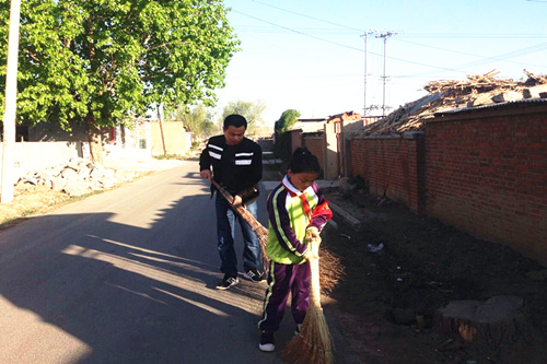 学生和家长一起打扫街道卫生